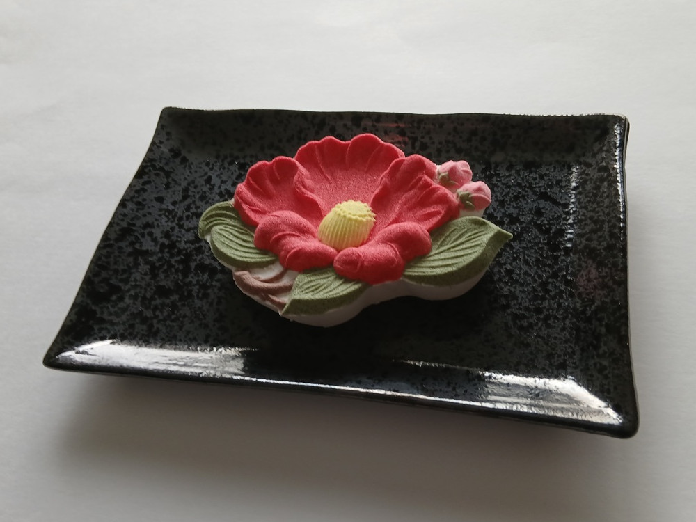 紅い椿をかたどった端正な落雁、冬の茶菓のひとときに添えられる日本の和菓子