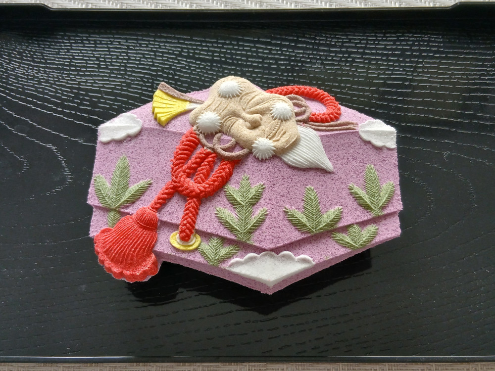 紅の紐に結ばれた箱に、祝いの意匠を納めた落雁