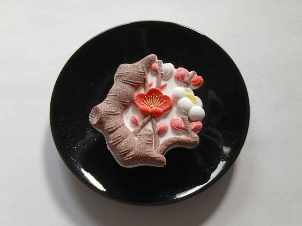 一本の枝に紅・白・淡彩の梅を表した和菓子の落雁「彩枝図」